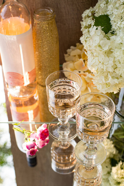 Rose blush wine in glasses. Bottle of rose wine with flowers on background. Prosecco. - Foto, afbeelding