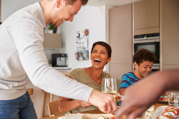 Father Serving As Multi-Generation Mixed Race Family Eat Meal Around Table At Home Together - Photo, image