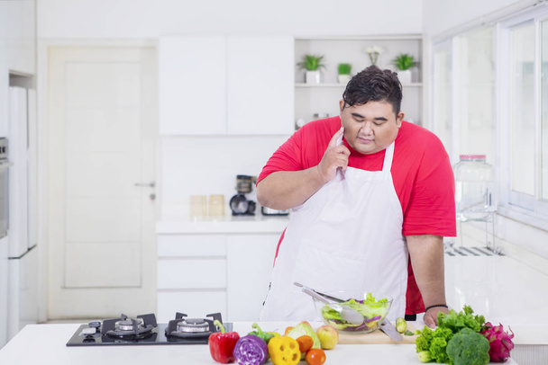Fat Asian man thinking for a cooking idea - Foto, Imagen