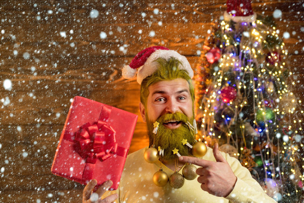 Liefergeschenke. Styling-Weihnachtsmann mit langem Bart posiert auf dem hölzernen Hintergrund. bärtiger Weihnachtsmann - Porträt aus nächster Nähe. - Foto, Bild