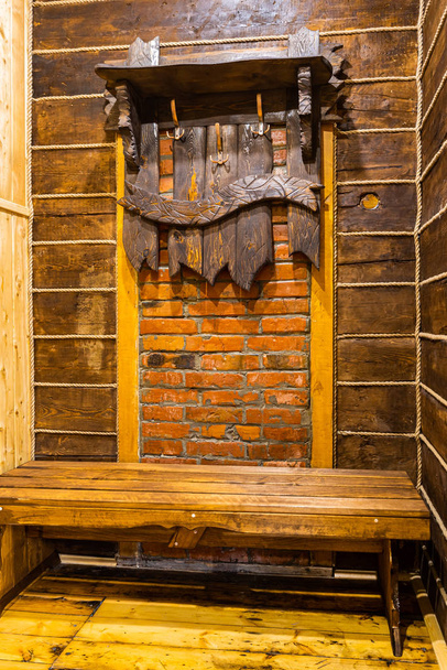 Primer plano de perchas de madera para ropa superior, hechas a mano de madera en el pasillo de la casa. Vista del pasillo en una casa de campo en paredes de madera y suelo
 - Foto, imagen
