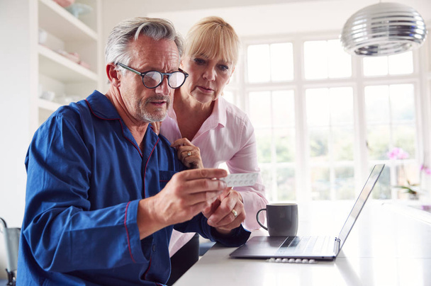 Mature Couple With Man In Wheelchair Looking Up Information About Medication Online Using Laptop - Photo, Image
