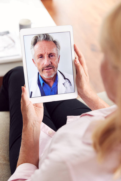 Mature Woman Having Online Consultation With Doctor At Home On Digital Tablet - Foto, Bild