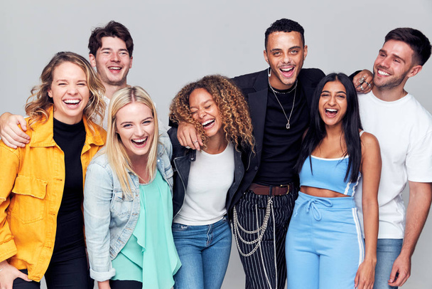 Group Studio Shot Of Young Multi-Cultural Friends Smiling And Laughing At Camera - Foto, imagen