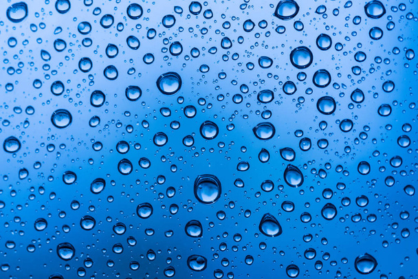 Water drops on glass window blue background after the rain in the autumn fall. - Fotografie, Obrázek