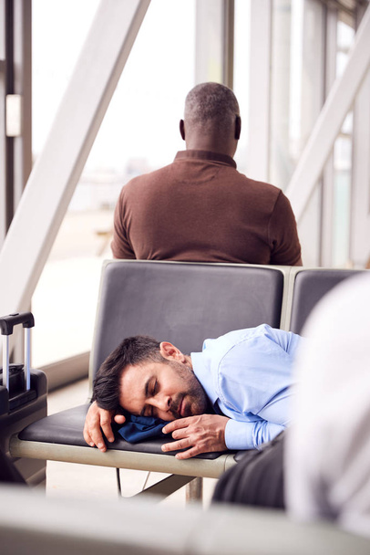 Businessman Sleeping On Seats In Airport Departure Lounge Because Of Delay - Foto, Bild