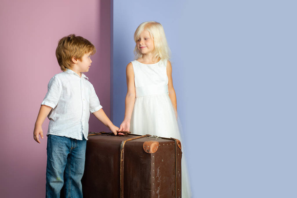 We are moving on. Relocation concept. Couple kids with suitcase. Happy childhood. Boy and girl cute friends. Friendship and love. Lovely tender children. Small kids friendship. Sincere friendship - Φωτογραφία, εικόνα