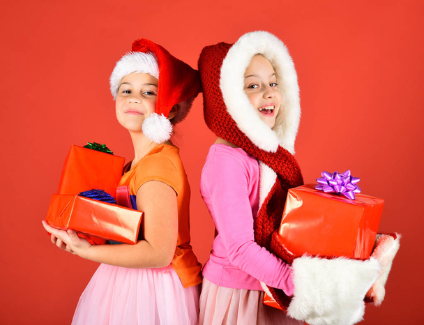 Sisters in Santa Claus hats with gift boxes - Valokuva, kuva