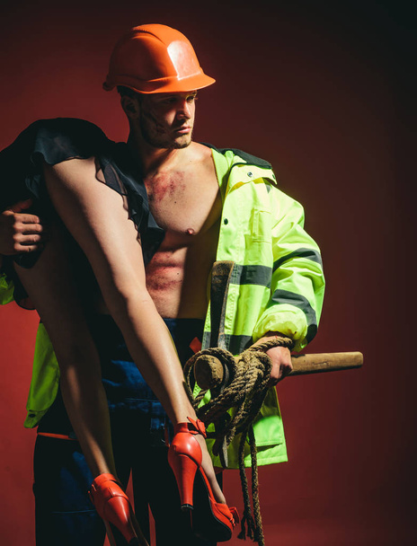 Muscle man holding sexy woman. Firefighter hot and sexy. Muscular man. Hot and sexy. Beautiful passionate couple. Rescuer firefighter or miners - risky occupations concept. Beautiful young couple. - Foto, Imagen