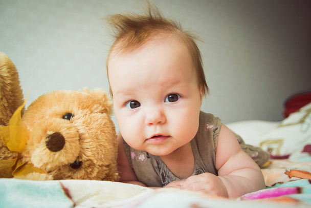 Baby plays with a teddy bear - Zdjęcie, obraz