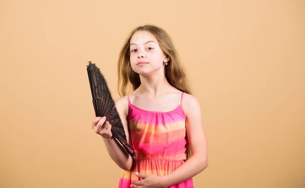 Cooling and ventilation. Conditioning system. Climate control. Air conditioner. Waving to create current air. Little girl waving elegant fan. Summer heat. Fresh air. Kid girl fanning herself with fan - Фото, изображение