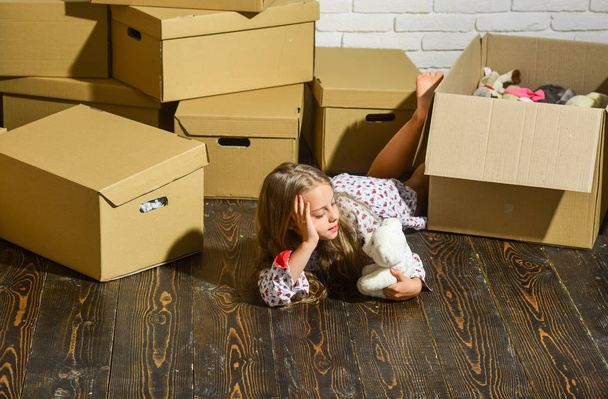 The Lifestyle You Deserve. happy little girl with toy. Cardboard boxes - moving to new house. purchase of new habitation. playing into new home. new apartment. happy child cardboard box - Photo, image