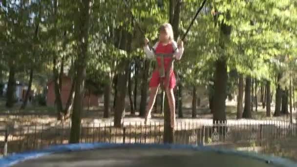Ragazza che salta attaccata su un trampolino nel parco estivo
. - Filmati, video