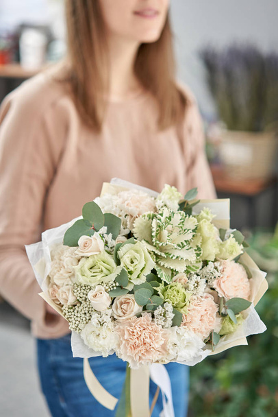 European floral shop. Beautiful bouquet of mixed flowers in womans hands. the work of the florist at a flower shop. Delivery fresh cut flower. - Foto, Imagem