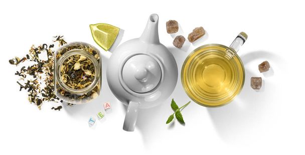 Groene thee met aromatische toevoegingen en accessoires. Bovenaanzicht op witte achtergrond - Foto, afbeelding