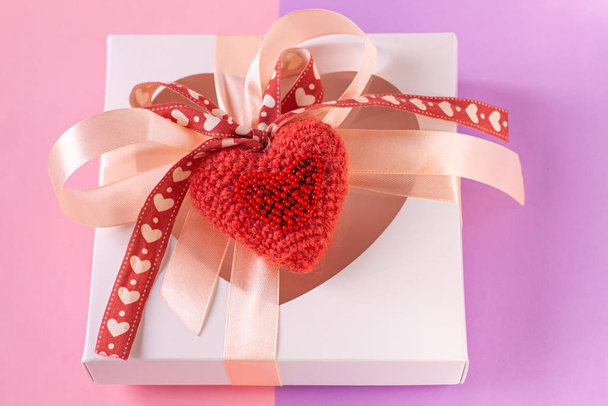 Kalp şeklinde pencere ve kart etiketli beyaz hediye kutusu. Pastel mor arka plan düz, yaratıcı minimum konsept.. - Fotoğraf, Görsel
