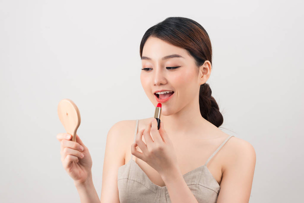 girl makes up with lipstick and mirror - 写真・画像