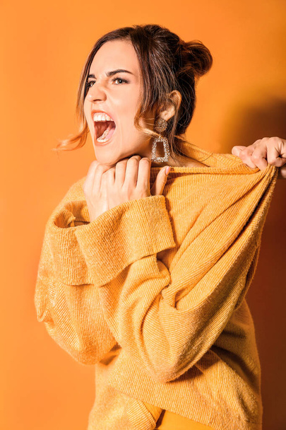 Aggressive fashionable young woman on color background - Foto, Imagem