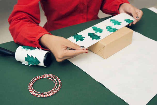 梱包のためのクリスマスプレゼントや箱。クリスマスの飾り、包装紙、木の枝. - 写真・画像