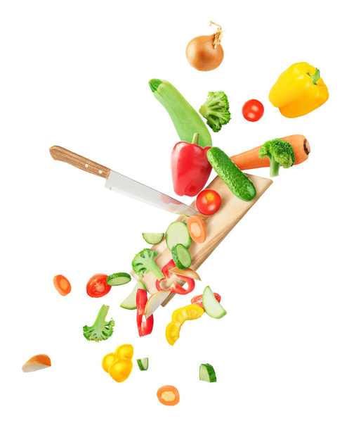 Vegetables fall on the board and cut with a knife isolated on wh - Fotoğraf, Görsel
