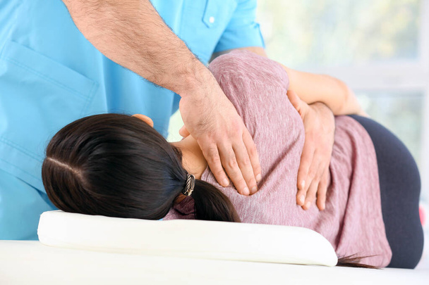 Physiotherapist working with female patient in rehabilitation center, closeup - Foto, imagen