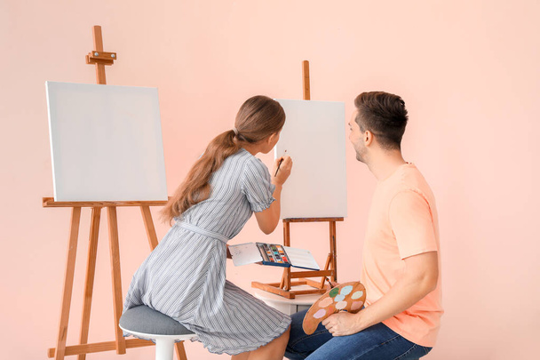 色の背景に若いアーティストのカップル - 写真・画像