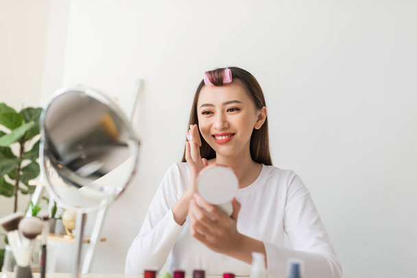 Joven blogger con cosméticos de maquillaje grabando video en casa
 - Foto, Imagen