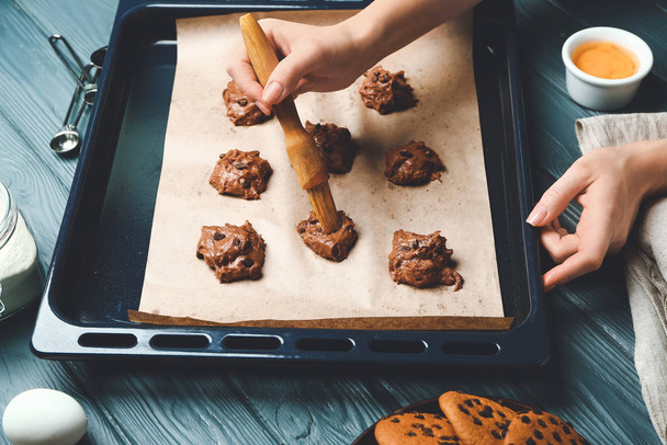 Femme cuisson de biscuits savoureux avec des pépites de chocolat à la maison
 - Photo, image