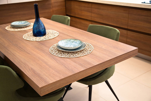 Cucina moderna, tavolo da pranzo in legno di noce e sedie verdi
 - Foto, immagini