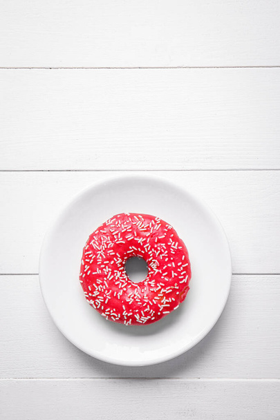 Plate with sweet tasty donut on white wooden background - Foto, Imagem