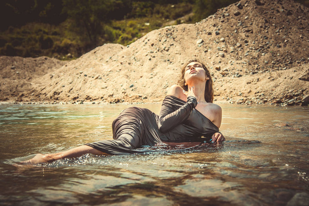 sexy and sensually woman lying in the river coast - Photo, image