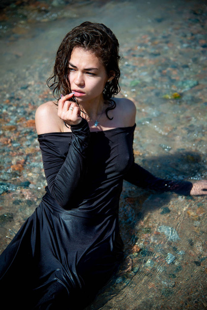 nuori seksikäs nainen märkä mekko poseeraa joen rannikolla
 - Valokuva, kuva