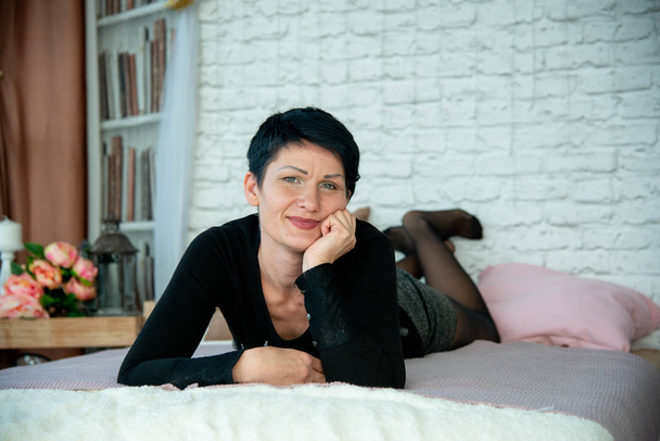 pretty brunet woman close up portrait posing on bed on photo studio background - Fotoğraf, Görsel