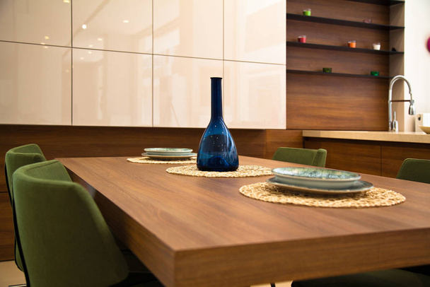 Сучасна кухня, дерев'яний обідній стіл з горіхами та зелені стільці
 - Фото, зображення