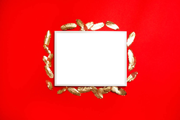 Kırmızı arkaplanda altın yapraklı beyaz, boş kartpostal şablonuyla yaratıcı dikey kompozisyon. - Fotoğraf, Görsel