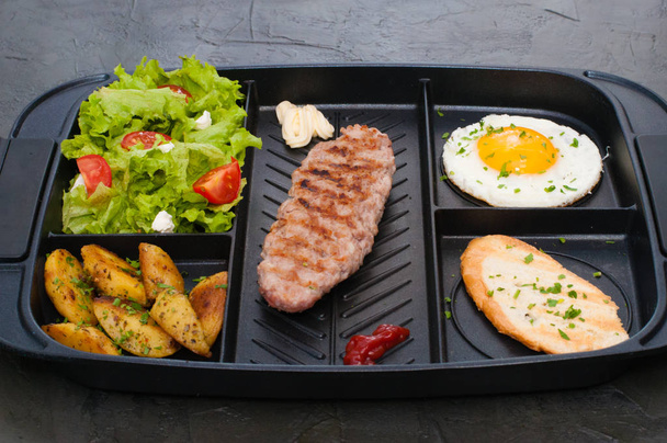 Завтрак, котлета или стейк, томатный салат, жареная картошка, крутон и жареное яйцо
 - Фото, изображение