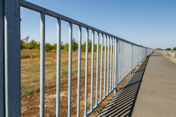 kerítés a mező és a gyalogos sétány között - Fotó, kép