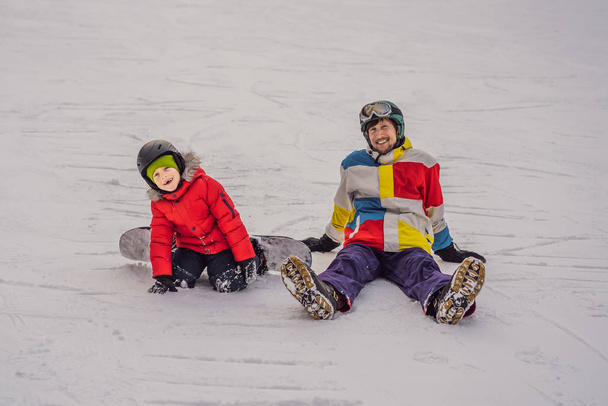 Snowboard instructor teaches a boy to snowboarding. Activities for children in winter. Childrens winter sport. Lifestyle - Foto, afbeelding