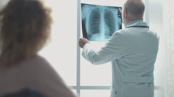 Arzt überprüft Röntgenbild des Patienten - Foto, Bild