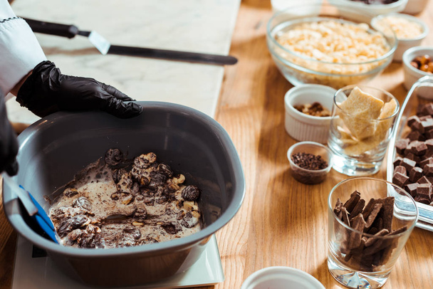 vista recortada del chocolatero mezclando chips de chocolate en un tazón
  - Foto, Imagen
