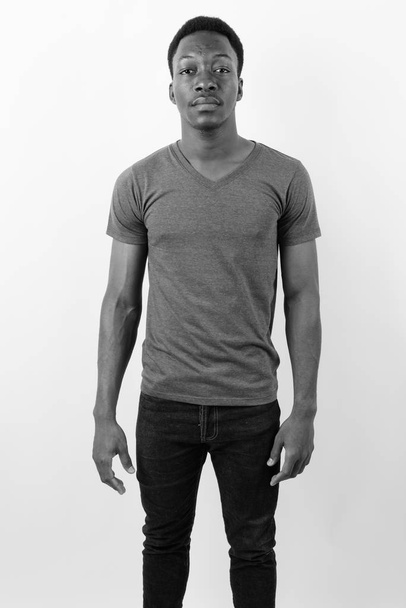 Studio shot of young handsome African man against white background in black and white - Fotografie, Obrázek
