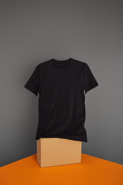 t-shirt basique noir sur cube sur fond gris et orange
 - Photo, image