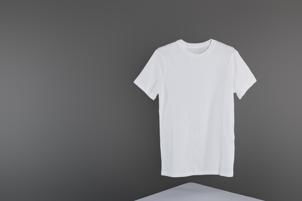 blank basic white t-shirt on grey background - Foto, Imagem