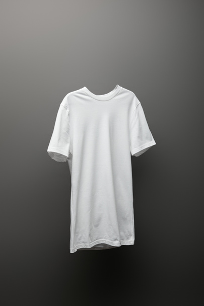blank basic white t-shirt on grey background - Foto, imagen