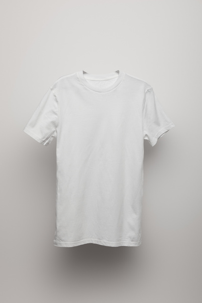 blank basic grey t-shirt on grey background - Fotó, kép
