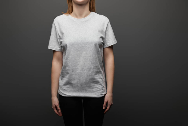 vue recadrée de la femme en blanc t-shirt gris basique sur fond noir
 - Photo, image