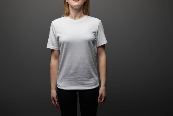 cropped view of woman in blank basic white t-shirt on black background - Photo, Image