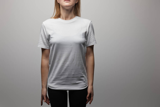 vista ritagliata della donna in bianco bianco di base t-shirt su sfondo grigio
 - Foto, immagini