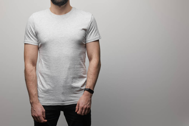cropped view of bearded man in blank basic grey t-shirt isolated on grey background - Fotó, kép