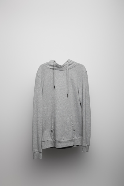 blanco basic grijze hoodie op grijze achtergrond - Foto, afbeelding